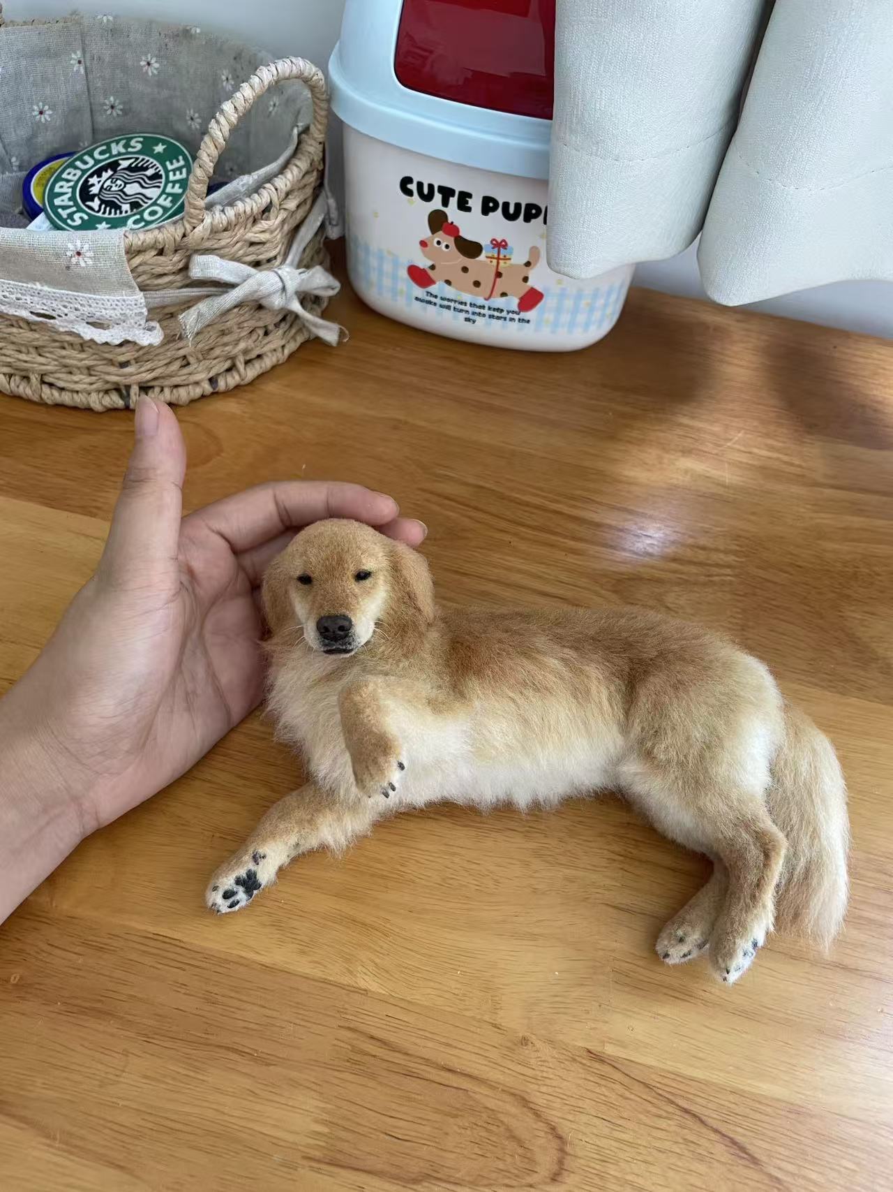 Custom mini wool felt dog sculpture held on a tabletop