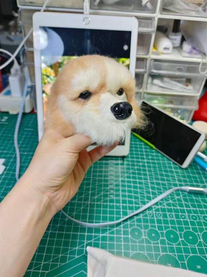 Mini wool felt dog head charm being held beside the reference photo