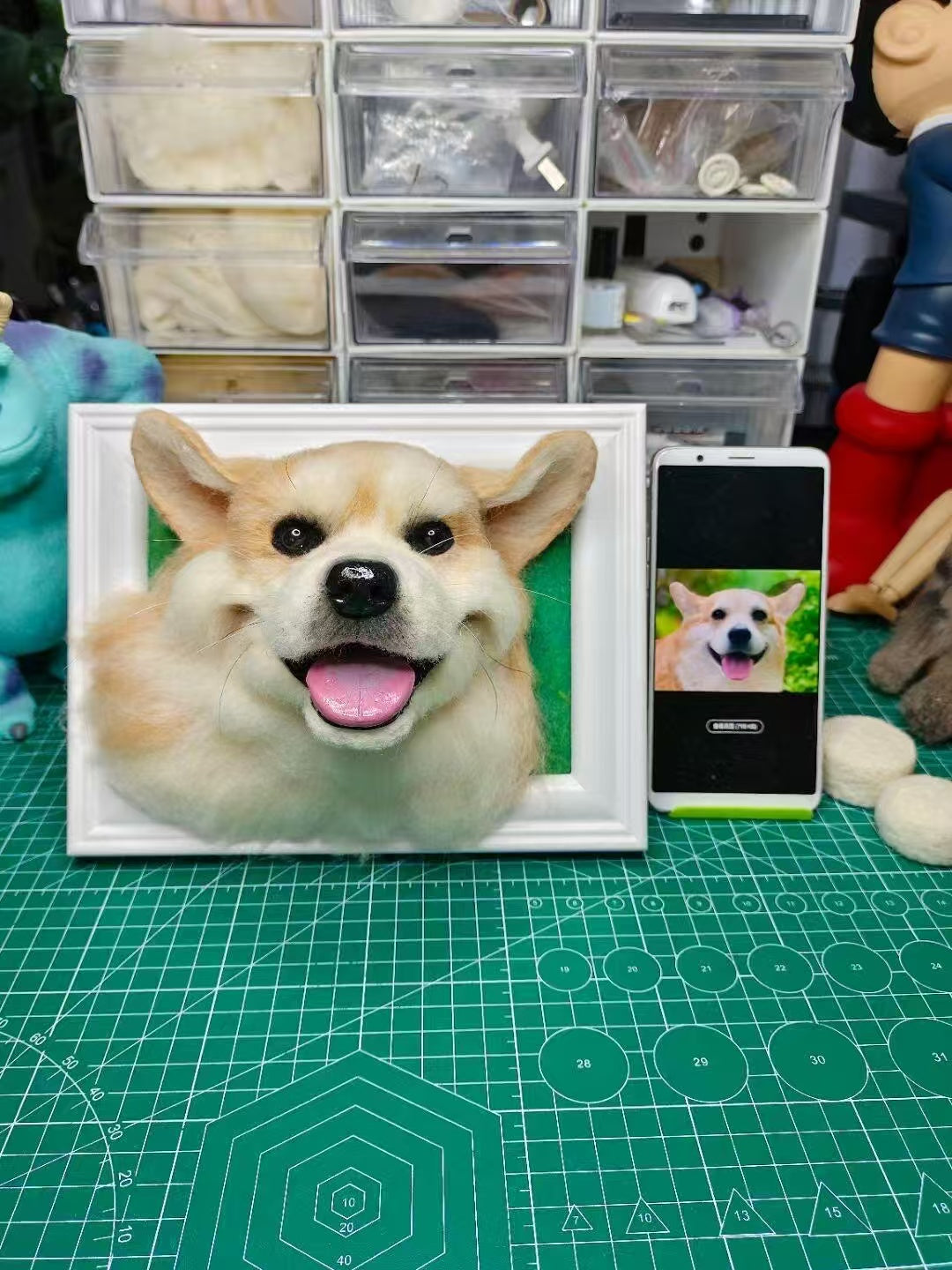 Custom 3D wool felt dog portrait in frame shown beside the pet photo